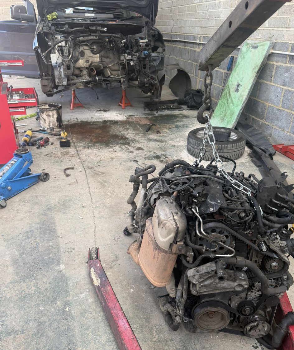 Engine lifted out of a car at the Elite Mechanics workshop