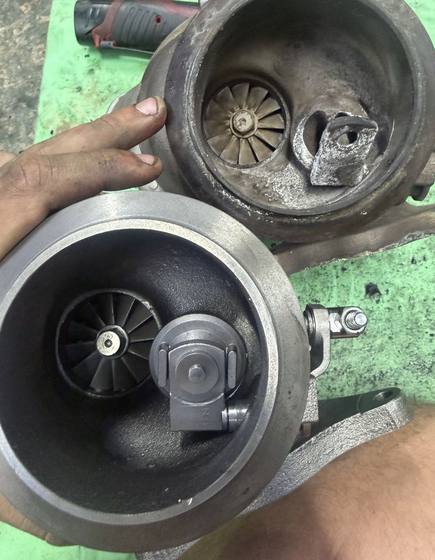 Old and new turbocharger compared during a turbo replacement